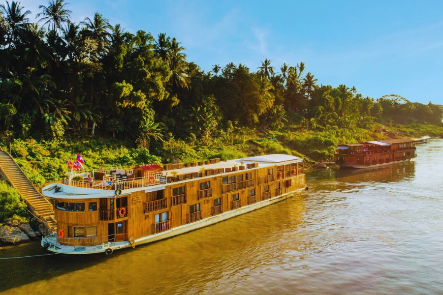 Elegant Mekong River Cruise docked beside lush jungle scenery with Auasia Travel